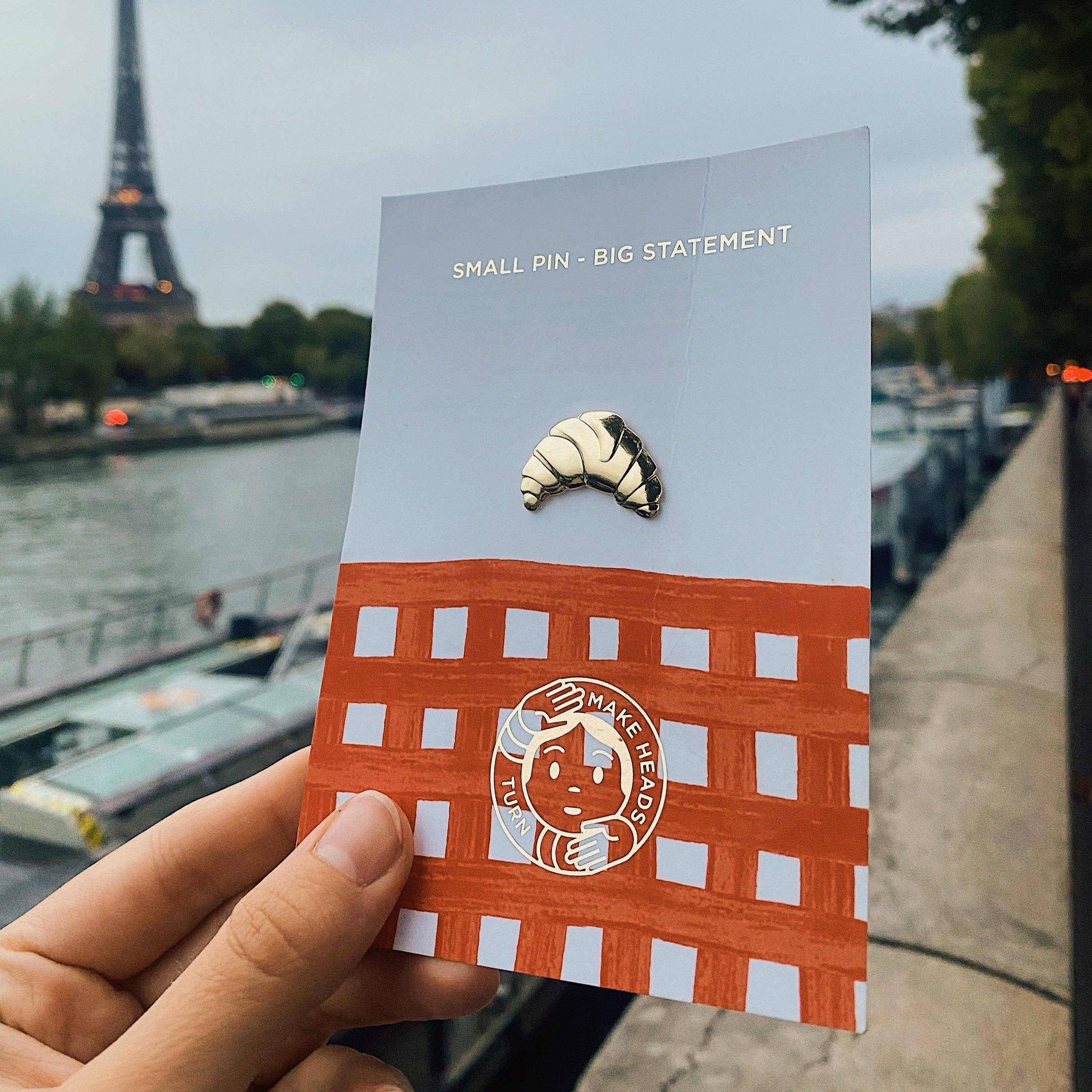 Croissant als Anstecker und der Eiffelturm im Hintergrund