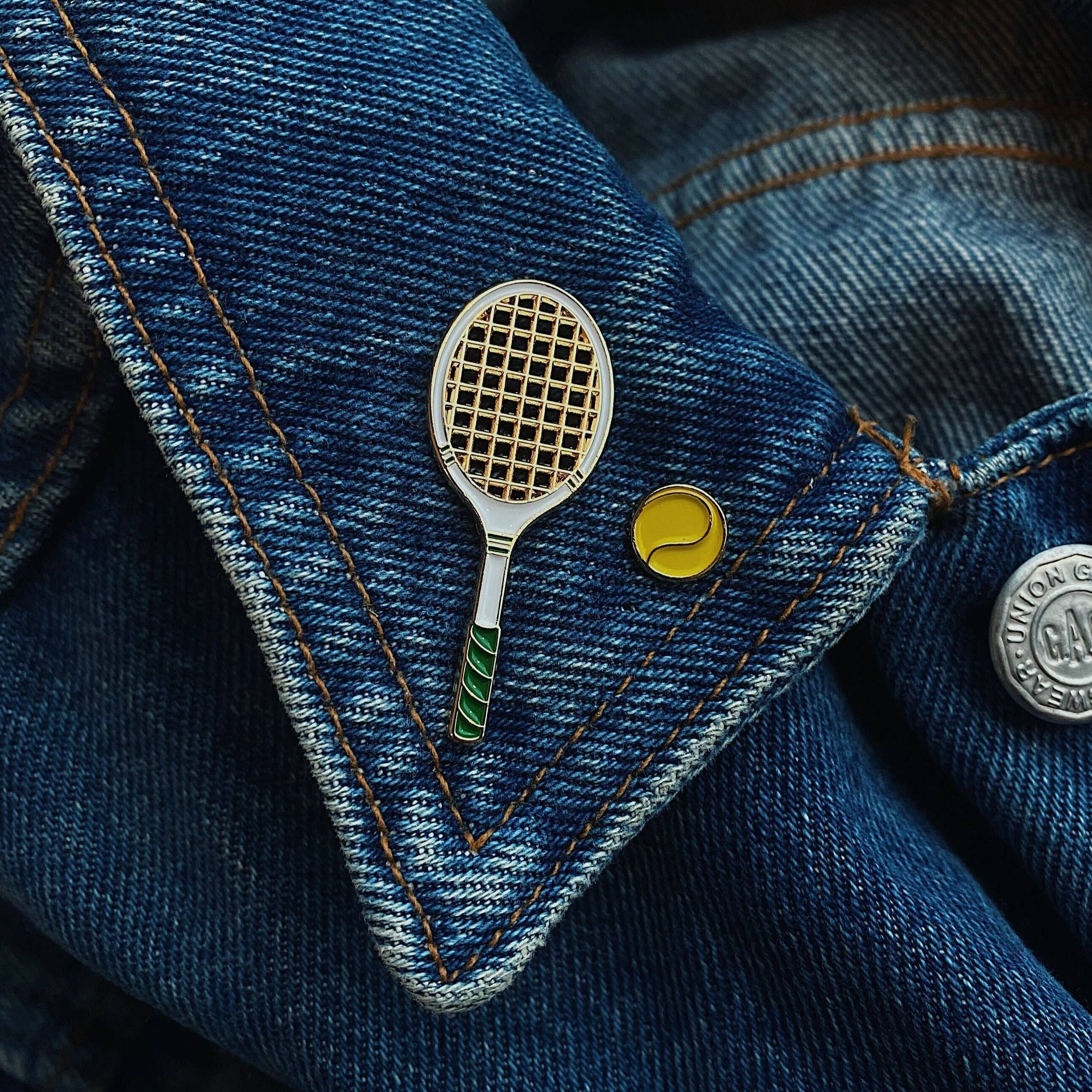 Emaille-Pin in Form eines Tennisschlägers auf einer Jeansjacke