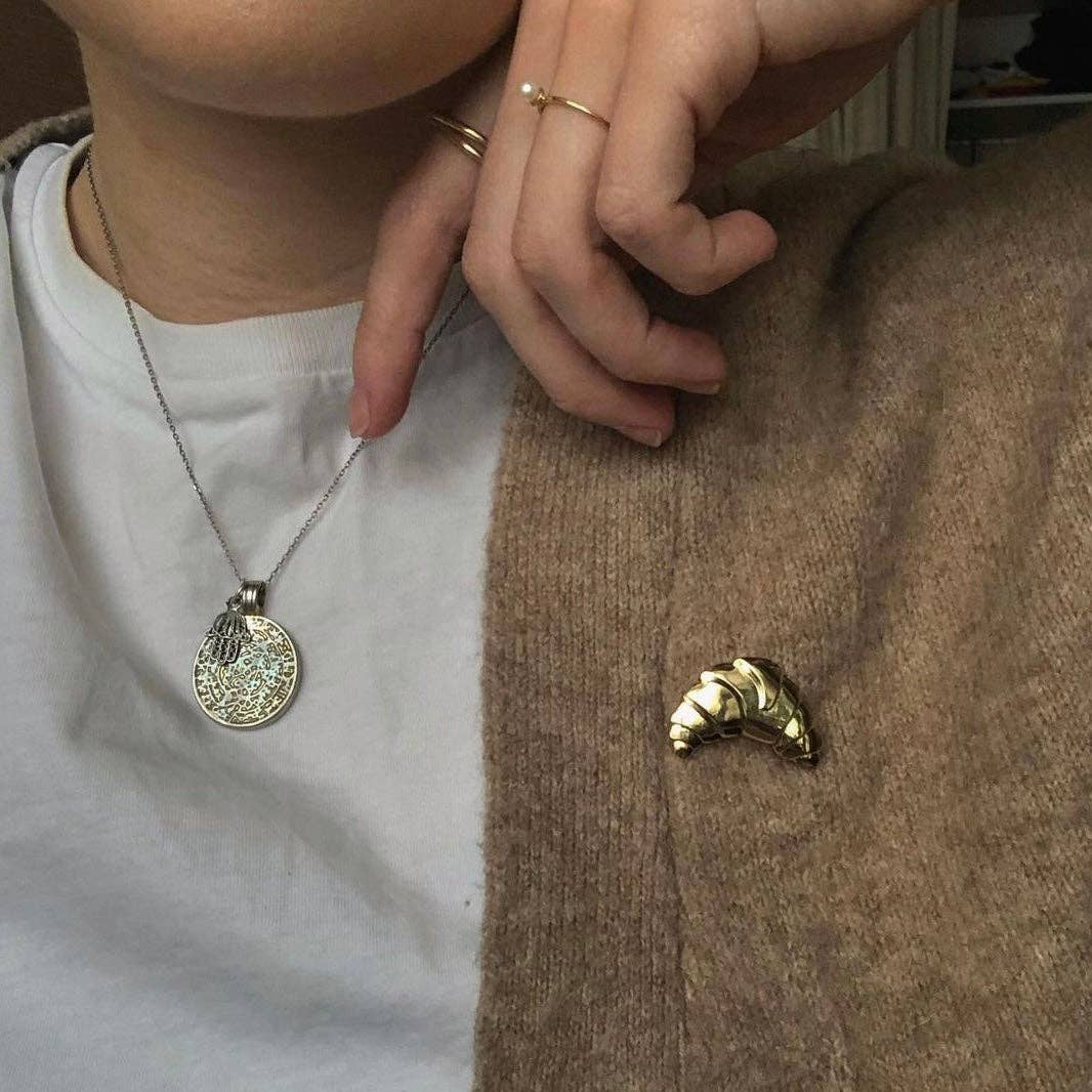 Croissant Anstecker an einer Strickjacke